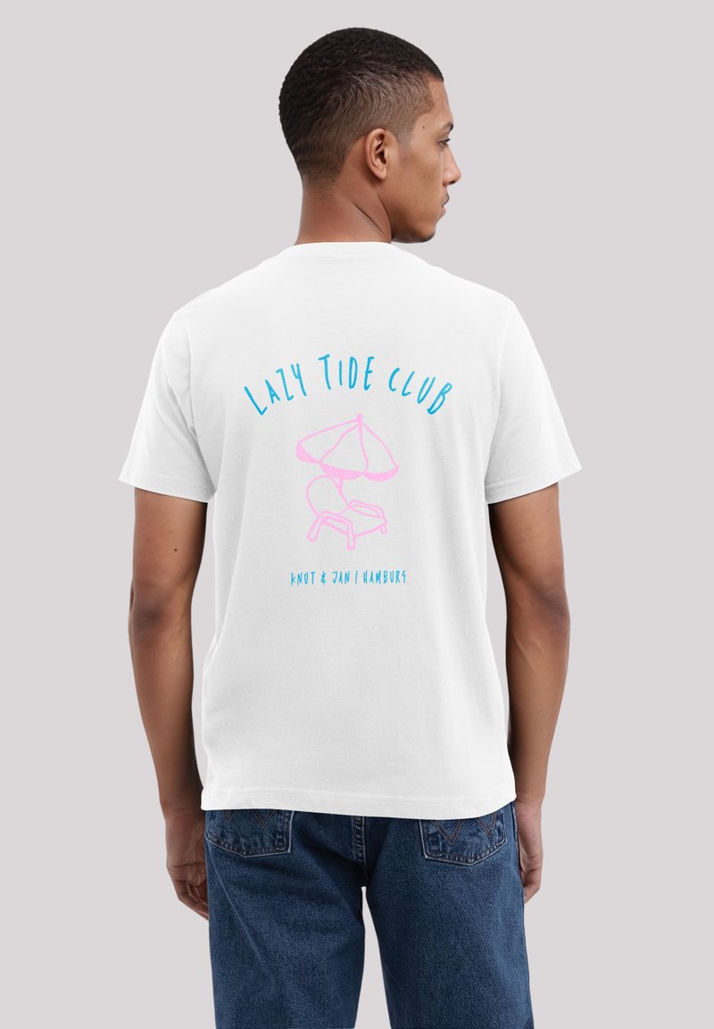 Weißes Baumwoll-T-Shirt mit einem pinken und blauen Grafikmotiv auf der Rückseite, das den Text "LAZY TIDE CLUB" sowie ein Bild eines Stuhls und eines Sonnenschirms zeigt.