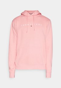 Světle růžová mikina s kapucí a přední kapsou, stahovací šňůrkou a bílým textem "Tommy Jeans" s malým logem umístěným na hrudi.