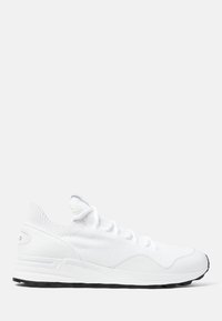 Baskets de sport blanches avec un dessus en tricot, fermeture à lacets, accents texturés et semelle extérieure en caoutchouc noir pour une adhérence optimale.