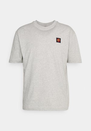 T-shirt gris clair à manches courtes avec un petit patch carré du logo Santa Cruz sur le côté gauche de la poitrine.