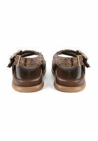 Sandalias marrones con un upper texturizado, hebilla ajustable y una plantilla lisa de color marrón oscuro. La suela es de color marrón claro y ligeramente contorneada.