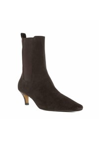 Bottine en suede marron avec un bout pointu, un petit talon et des panneaux latéraux élastiques pour un enfilage facile. Texture lisse dans son ensemble.
