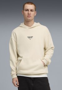 Felpa color crema con tasca frontale, cappuccio e stampa del logo "PORSCHE LEAGUE TURBO CLUB". Tessuto morbido e testurizzato, con polsini a coste.