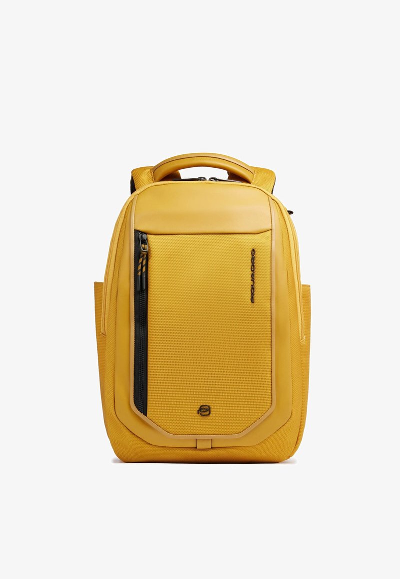 Sac à dos compact jaune avec poche zippée à l'avant, poignée supérieure rembourrée et compartiments latéraux, conçu pour une utilisation quotidienne et les voyages.