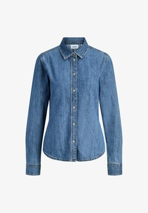 Camicia di jeans azzurro chiaro con maniche lunghe, colletto appuntito e chiusura frontale abbottonata. Presenta cuciture visibili e un orlo curvo.