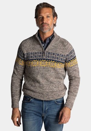  gebreide trui in beige met een geribbelde kraag, met een blauw en geel geometrisch patroon op de borst. Zachte textuur, aansluitend ontwerp.