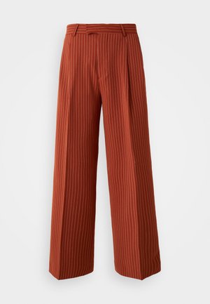 Rustfargede vide bukser med vertikale hvite striper, med høy midje-design og kantede detaljer, laget av et glatt stoff.