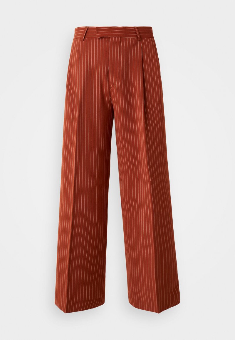 Pantalons larges couleur rouille avec des rayures verticales blanches, dotés d'une taille haute et de détails plissés, fabriqués dans un tissu doux.