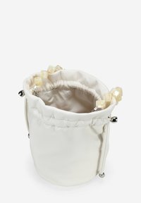 Bolso de bucket blanco de cuero con cierre de cordón, textura suave y acentos en forma de perla en las asas. Diseño simple y moderno.