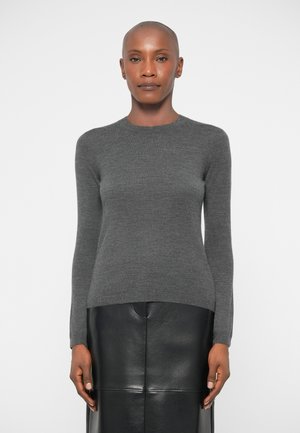 Gray long-sleeve sweater made of soft fabric with a crew neckline. It has a fitted silhouette and is paired with a black leather skirt.