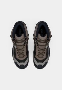 Botas de caminhadas castanhas e cinzas com uma superfície texturizada, collor acolchoado e detalhes em preto contrastantes. Apresentam uma sola robusta e um design de atacadores.