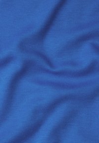 Textil i livlig blå, med en jämn, mjuk textur och fina ribbmönster som skapar mjuka vågor och veck över tygytan.