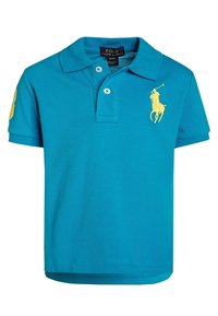 Turkos pikétröja i texturerat tyg. Har en tvåknappskrage, korta ärmar och en gul logotyp på bröstet och ärmen.