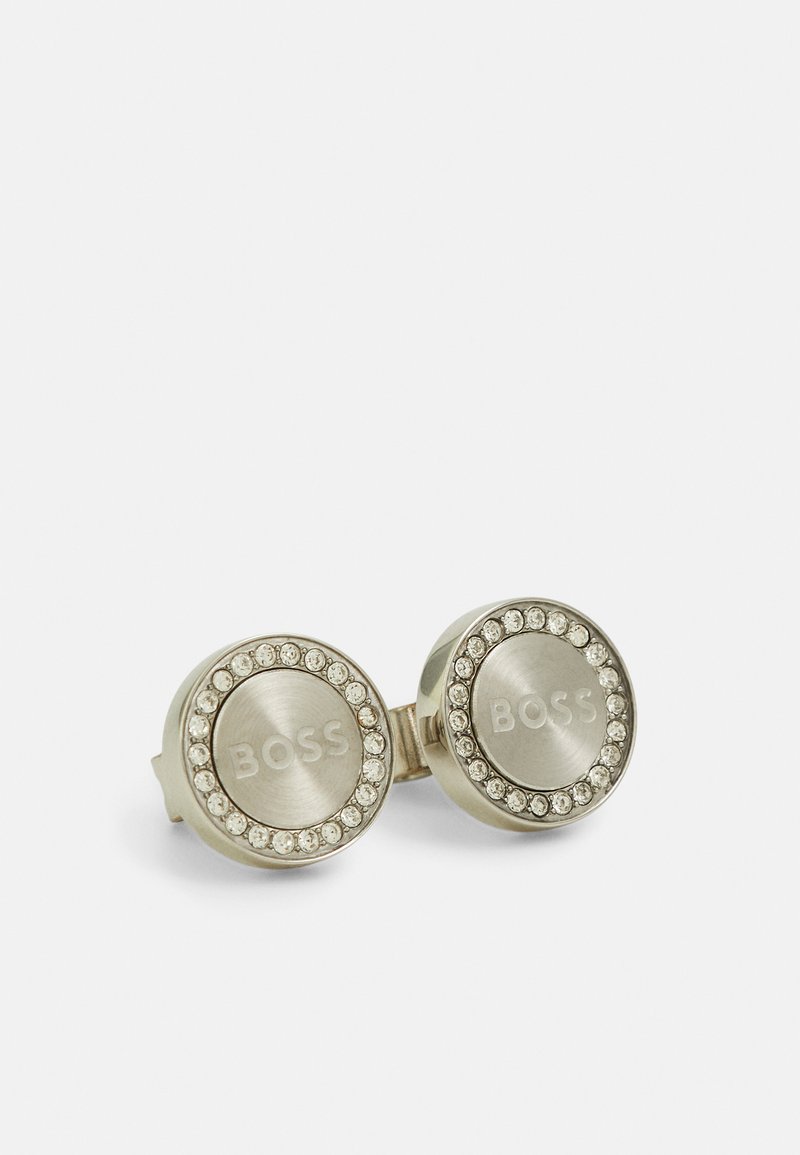 Metalliske sølv cufflinks med gravert "BOSS"-logo, omgitt av en ring med små klare krystaller, sirkulært design, polert tekstur.