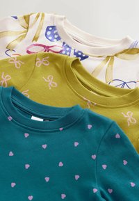 Tre sweatshirts staplade: en med ljus bakgrund och färgglada rosettmönster, en grön med rosa rosetter, och en teal med små rosa hjärtan.