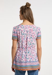 Lyserød blomstret bluse med korte ærmer, elastisk talje og flerfarvede mønstrede detaljer ved manchetterne og kanten. Glat, let stof.