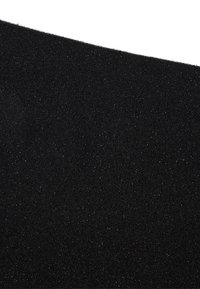 Primo piano di un tessuto nero testurizzato con sottili particelle luccicanti, che mostra il bordo diagonale su uno sfondo bianco.