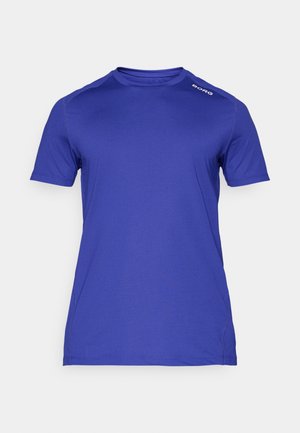 Karaliskā zilā īsā piedurknes sporta krekls, kas izgatavots no gludas, mitrumu vogojošas auduma. Tam ir apaļš kakla izgriezums un diskreta zīmola logo uz pleca.