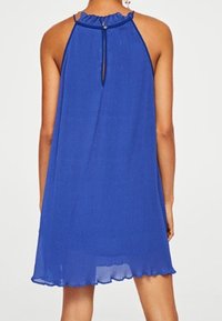 Robe halter bleu avec un encolure froncée et un bouton au dos. Caractéristiques d'un tissu fluide et texturé avec un ourlet en biseau.