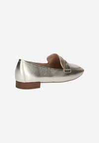 Metalen zilveren loafers hebben een puntige neus, een decoratieve band op de bovenkant en een lage houten hak voor stabiliteit.