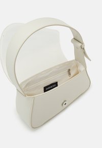 Petit sac à main blanc cassé avec une large bandoulière, fermeture à rabat et poche intérieure zippée étiquetée "even&ODD."
