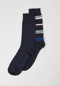 Marinefarbene Socken, wobei eine Socke dünne blaue Streifen und die andere horizontale Pastellstreifen hat. Aus weichem Material gefertigt, für maximalen Komfort entworfen.