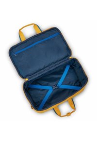 Borsa di stoffa gialla con un interno blu navy, dotata di una tasca con zip blu e spallacci regolabili per il contenuto. Texture soffice con design trapuntato.