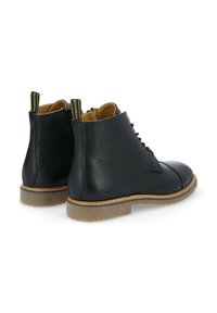 Bottines en cuir noir avec une finition texturée, à lacets à l'avant et semelle beige contrastante. Comprend une languette avec le logo de la marque.