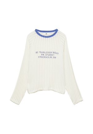 T-shirt blanc côtelé à manches longues avec col rond bleu et texte bleu disant "BE FEARLESSLY BOLD PR STUDIO STOCKHOLM, SW" sur le devant.