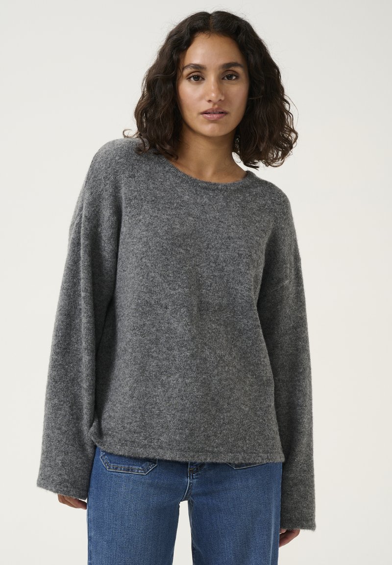 Gray wool sweater with a wide round neckline and long sleeves, featuring a soft texture and a relaxed fit. Paired with blue jeans.