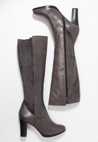 Bottes grises jusqu'aux genoux en cuir lisse et en daim, avec une fermeture éclair et un talon épais.