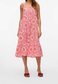Sukienka w kwiatowy wzór, bez rękawów, o długości midi w kolorze różowym i białym, z guzikami z przodu i falbaniastymi ramiączkami.