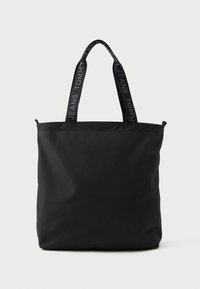 Μαύρη τσάντα tote φτιαγμένη από ανθεκτικό ύφασμα, με διπλούς ιμάντες και ανάγλυφο λογότυπο, καθώς και φερμουάρ στην κορυφή για ασφαλή πρόσβαση.
