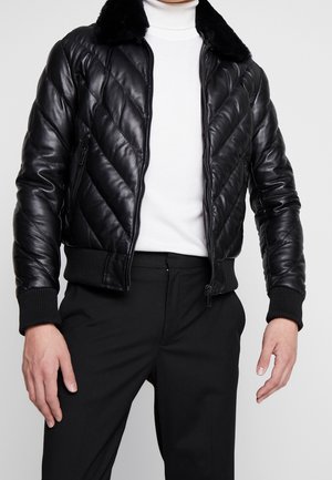 Schwarze Leder-Bomberjacke mit einem gesteppten Muster, flauschigem Kragen, gerippten Bündchen und Saum, mit einem Frontreißverschluss und seitlichen Taschen.