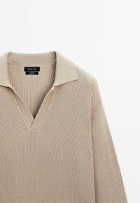 Pull à manches longues en tricot beige avec un col en V profond et une texture côtelée, étiquette Massimo Dutti, en 100 % coton.