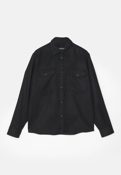 Black button-up shirt with long sleeves, two chest pockets, and a soft, textured fabric. Features a classic collar and button closure.