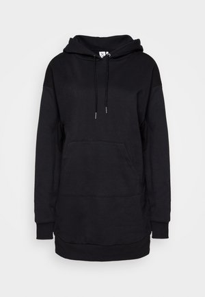 Sweatshirt à capuche noir en tissu doux. Il dispose d'une poche kangourou, d'une capuche avec cordon de serrage et de poignets côtelés. Design simple et oversize.