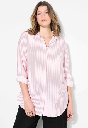 Camicia a maniche lunghe di colore rosa chiaro con sottili righe verticali rosse, maniche arrotolabili e orlo curvo. Il tessuto sembra morbido e leggero.