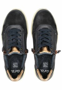 Černé semišové tenisky s námořnickými tkaničkami, kovovými detaily, bočním zipem a slonovinovými podrážkami. Na stélkách je vytištěno "HIGH SOFT".