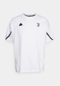 Biała koszulka treningowa Juventusu z krótkim rękawem, z czarnym logo Adidasa na lewej piersi i emblematem Juventusu na prawej piersi.