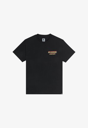 Črna bombažna majica s kratkimi rokavi, ki na sprednji strani prikazuje pisano "DCSHOE COMPANY" logo, ter zaobljen ovratnik.