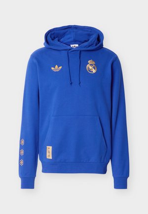 Modrá mikina s kapucí s logy Adidas a Real Madrid ve zlaté barvě, kapsou na břiše, stahovací kapucí a třemi malými zlatými květy na levém rukávu.