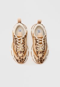 Zapatillas con estampado de leopardo, parte superior de malla y ante en color beige, con cordones blancos, una lengüeta en el talón y una suela de goma exagerada.