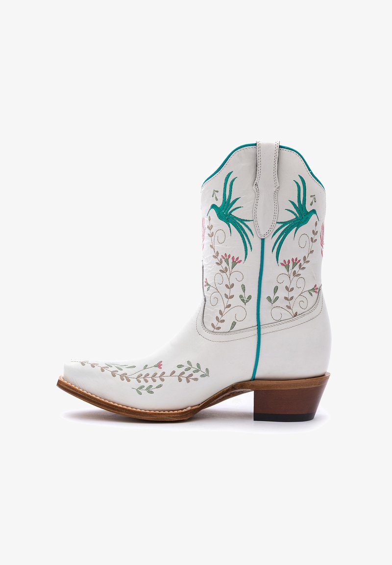 Stivale da cowboy in pelle bianca con ricami floreali verdi e rosa, punta affusolata, dettagli cuciti e tacco in legno.