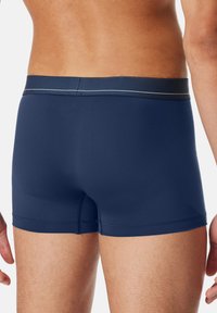 Boxer da uomo blu navy realizzati in tessuto elasticizzato con una cintura morbida, caratterizzati da cuciture piatte e una texture liscia.