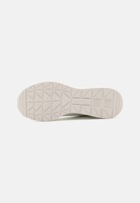 Hvit sneakersåle med teksturert grep, med geometrisk mønster og fremtredende merkevare. Glatt overflate, avrundet tådesign.