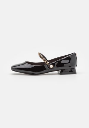 Chaussure Mary Jane en cuir verni noir avec petit talon, chaîne et détail perle sur la bride, vue de profil sur fond blanc.