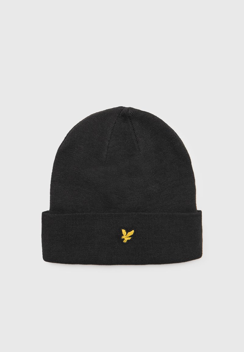Czarna dzianinowa czapka beanie z podwiniętym mankietem i małym żółtym logo orła z przodu. Tkanina wydaje się miękka o gładkiej fakturze.