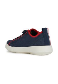 Zapatillas de lona azul marino con acentos rojos, punta redondeada, suela de goma blanca y una lengüeta en el talón. Incluye ojales para los cordones y ribete rojos.