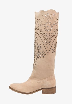Bota de ante beige hasta la rodilla con patrones de corte floral, parte superior con forma de ola y punta redondeada. El tacón bajo marrón añade estabilidad.